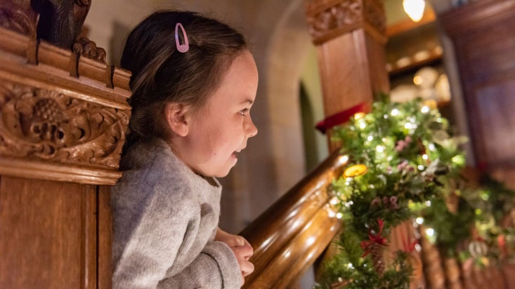 A girl looking at a festive festoon at Cragside, Northumberland